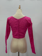 Pink long-sleeve top on a mannequin against a plain background