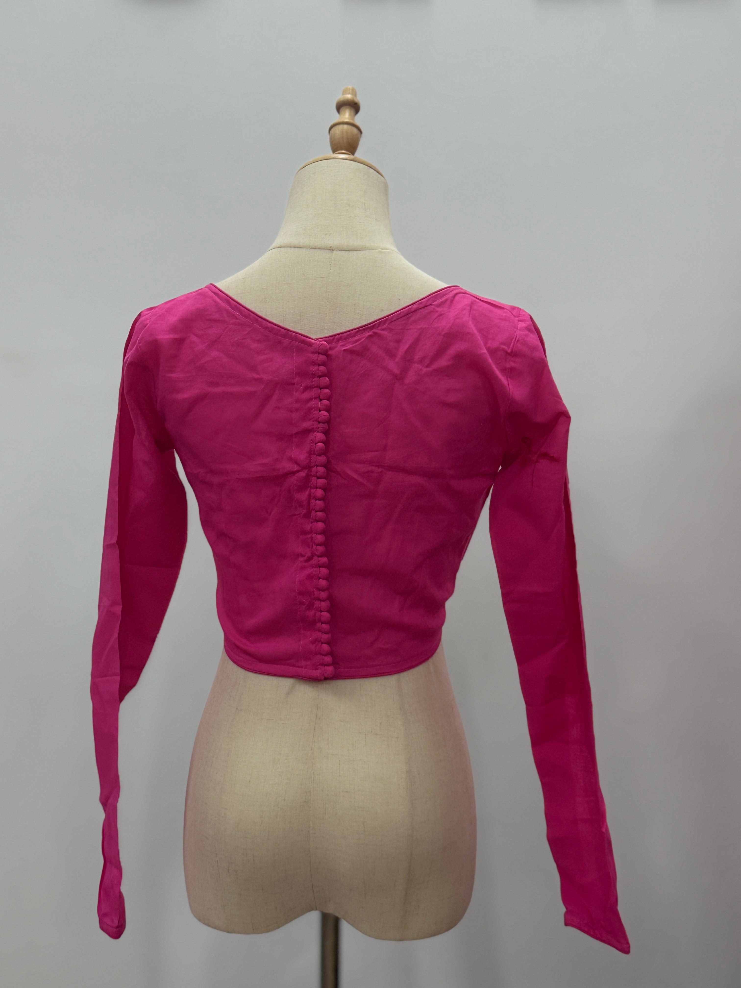 Pink long-sleeve top on a mannequin against a plain background